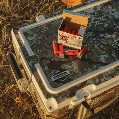 Hunting supplies sitting on top of a Kryptek Obskura camo hard cooler [88 qt] [48 qt]