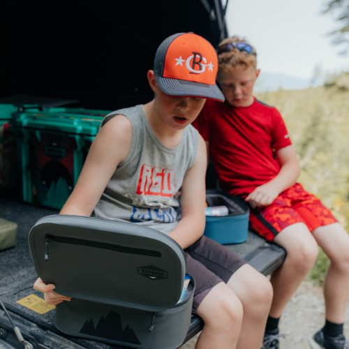 Two boys outside grabbing their lunch out of Cordova insulated cooler lunch bags [Yonder]