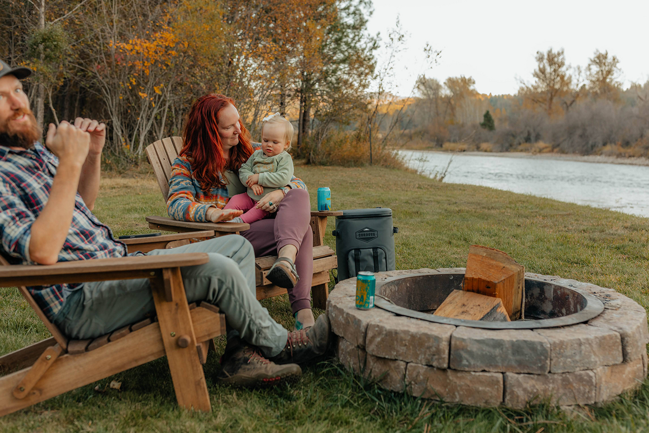 24 can gray backpack cooler being used for drinks while sitting next to campfire  [Yonder][Scree]