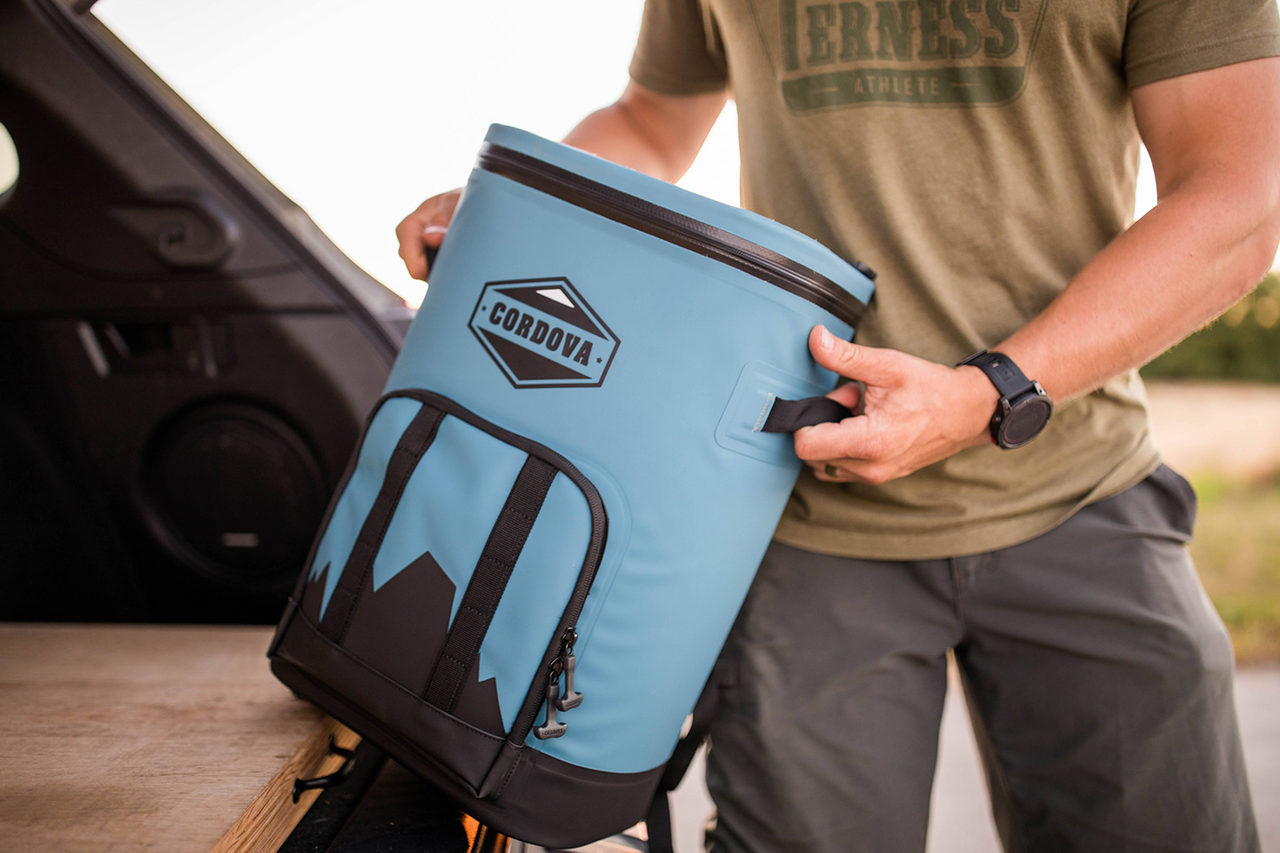 Lightweight blue cooler backpack being easily lifted out of vehicle [Yonder][Scree]